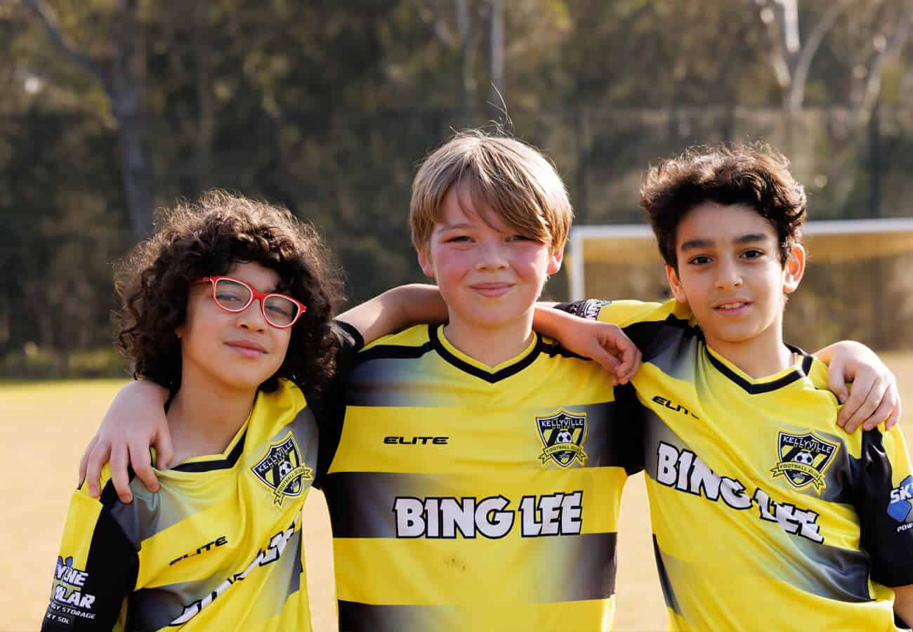 3 Kellyville United football players with arms around each other